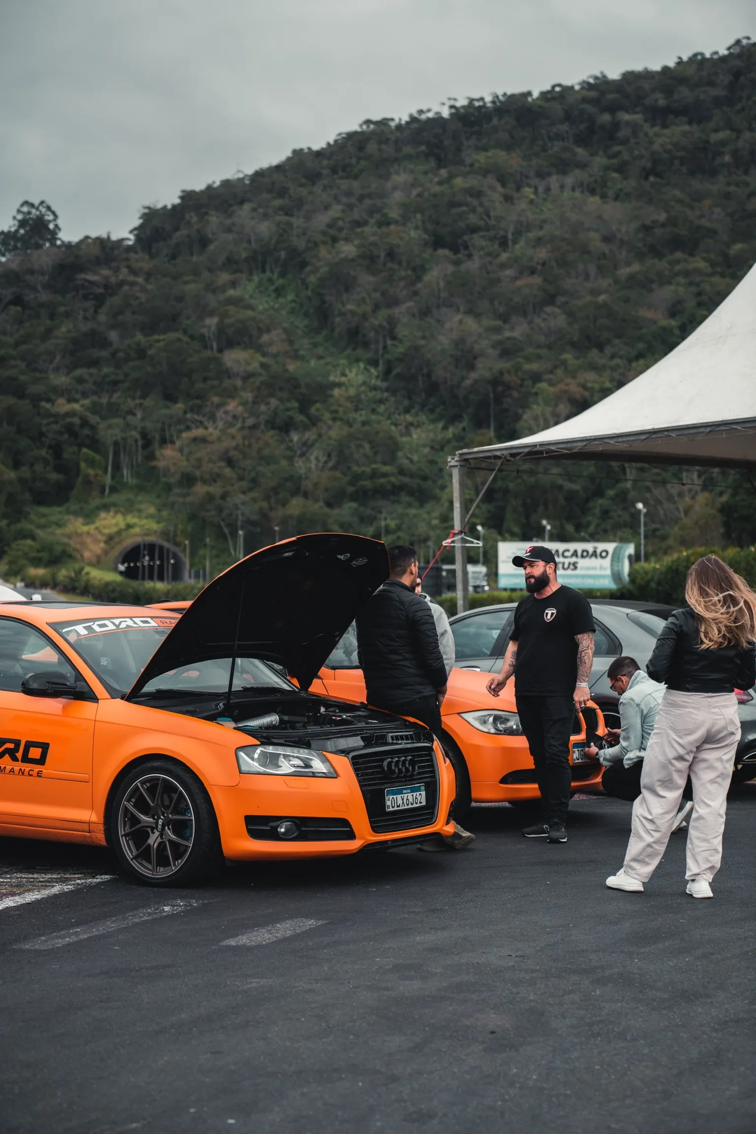 Carros Toro Performance laranja em evento externo com equipe